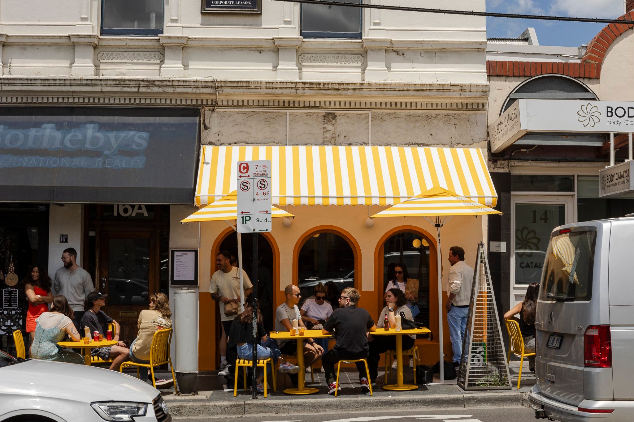 Street-facing view of Zita’s in South Yarra, featuring its signature yellow-and-white striped awning and minimalist façade. The exterior captures the cheerful, laid-back vibe of this Italian-style sandwich shop known for focaccia filled with premium ingredients and house-made spritzes. Perfect for takeaway or a sunny seat outside on Toorak Road.