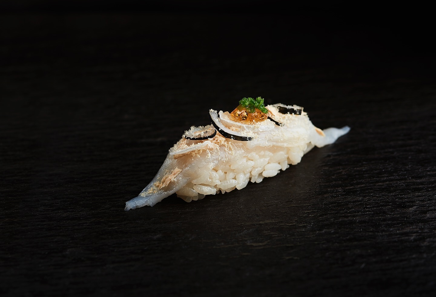 A meticulously crafted nigiri sushi at Minamishima, showcasing pristine seafood, expertly seasoned rice, and precise knife work in an intimate omakase setting.