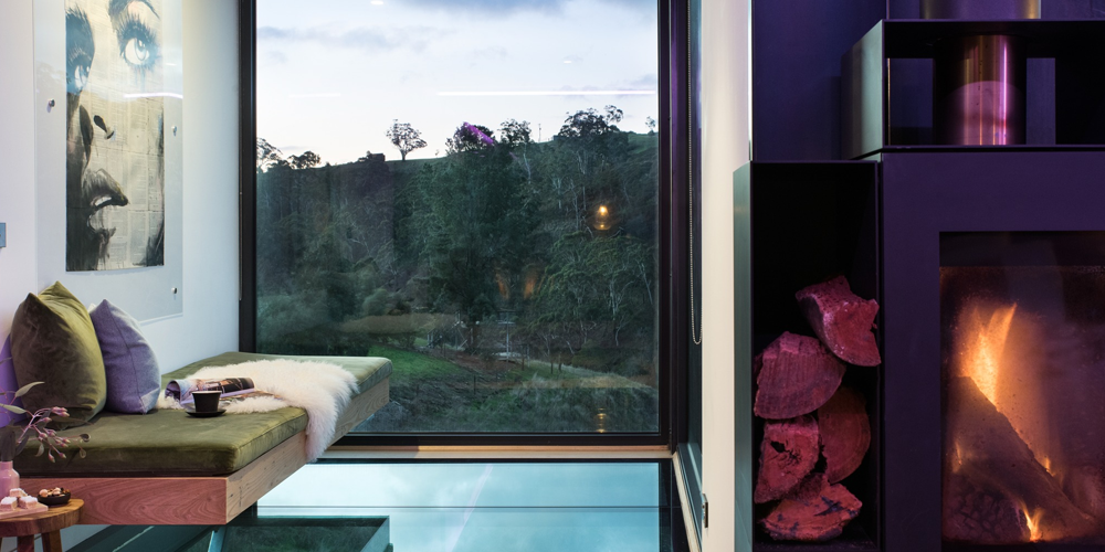 Architect-designed villa at Clifftop Hepburn featuring floor-to-ceiling glass, a suspended daybed, and panoramic bush views.